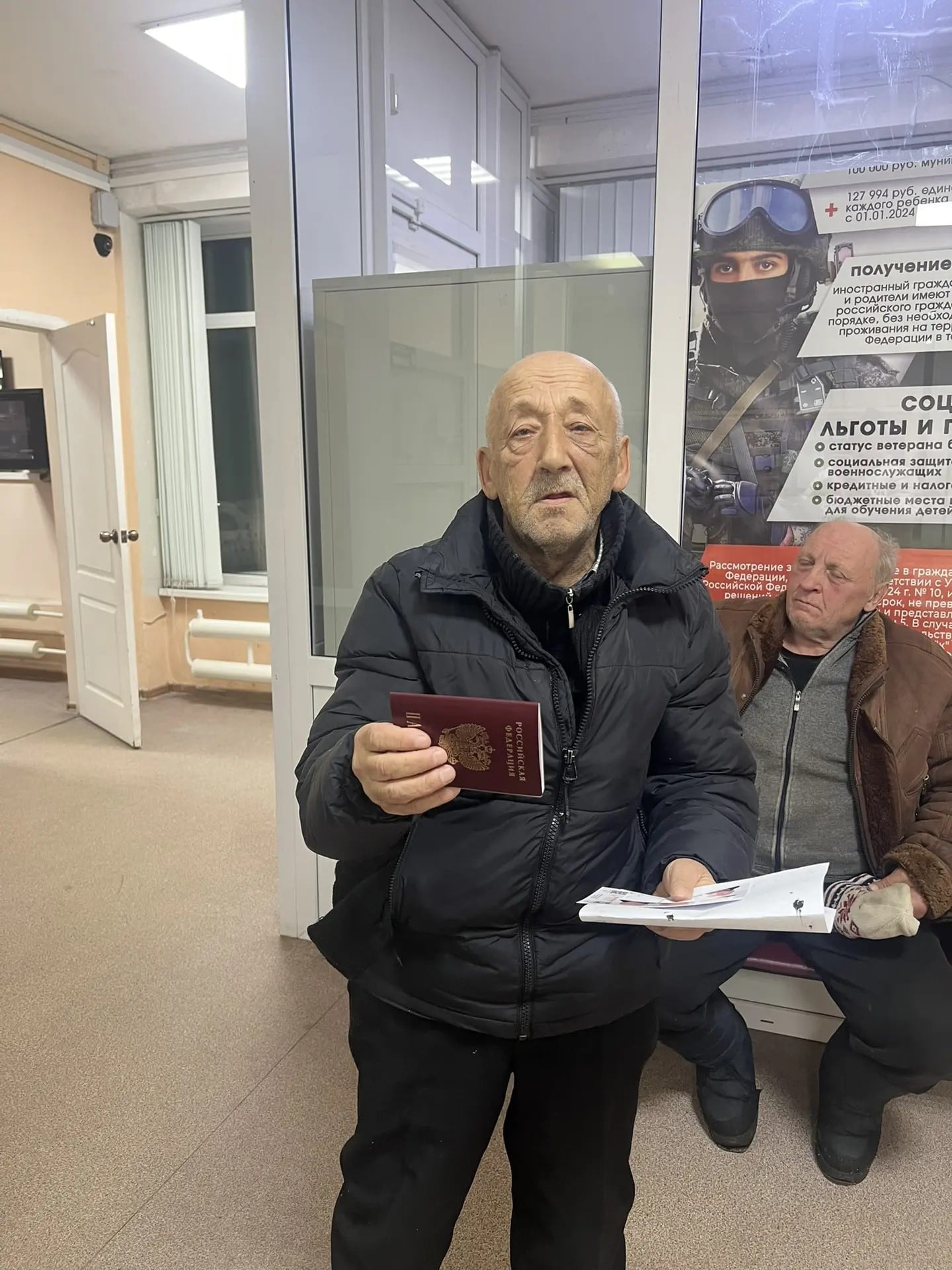 Мужчина с полученным паспортом в учреждении